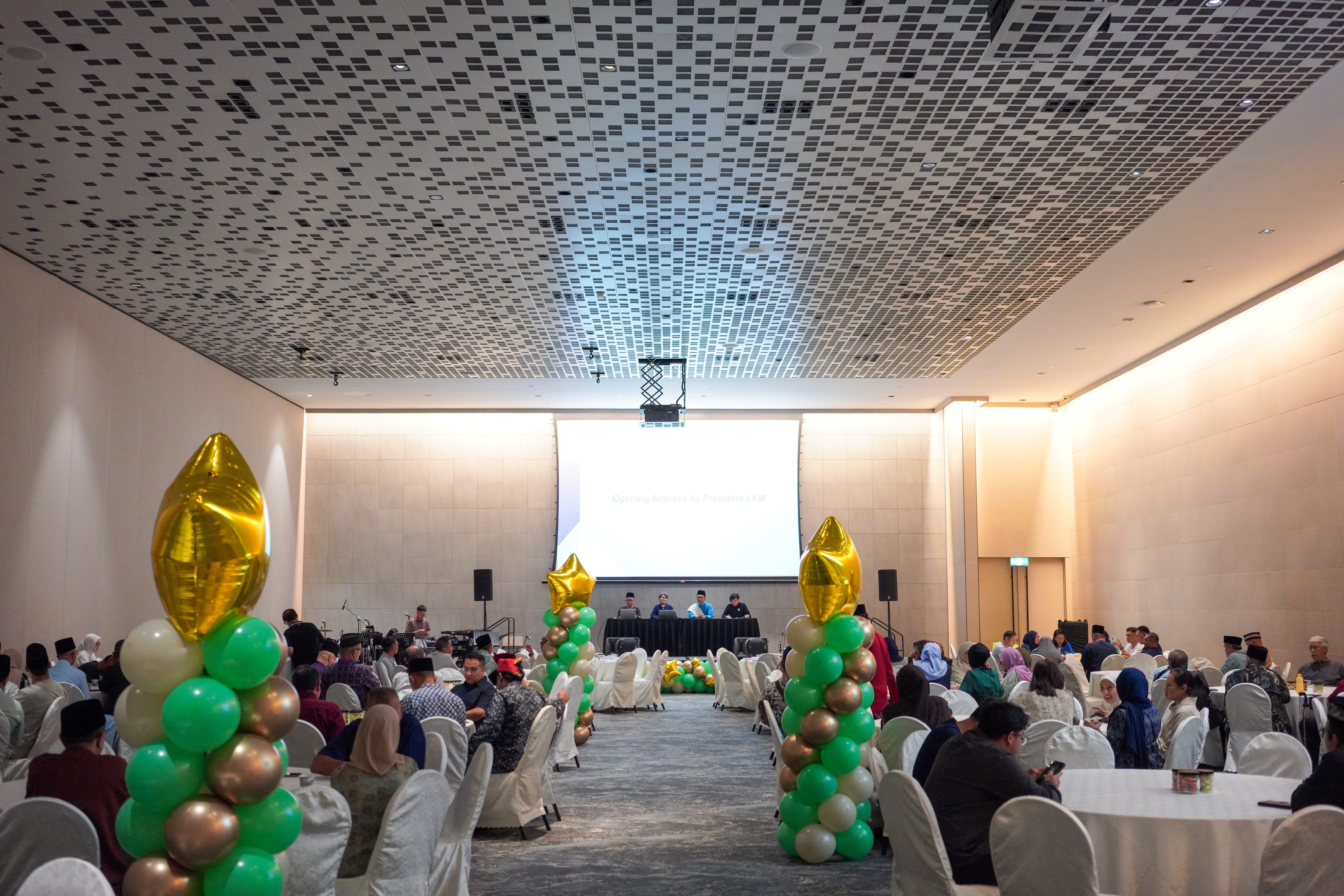 Wide view of the function hall showing guests seated at tables during the opening segment of the programme.